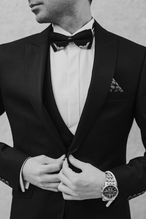Black and white photo of a man in a black suit and bowtie