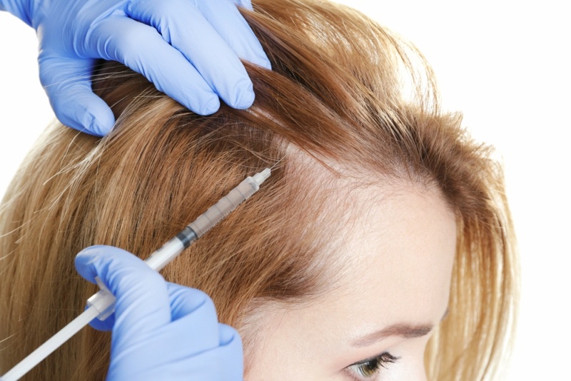 Young woman with hair loss problem receiving injection on white background, closeup